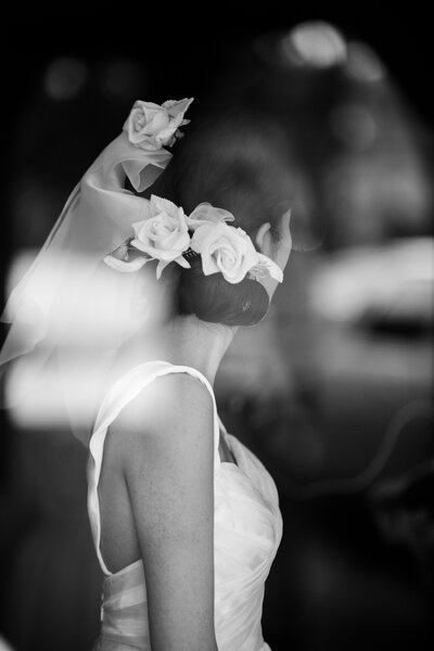 Bride wearing floral veil looking out into the distance, away from camera