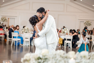 Newlyweds embracing during their first dance at a beautifully planned luxury wedding reception in Raleigh, NC.