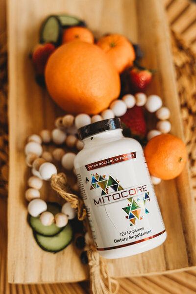 Bottle of vitamins next to oranges