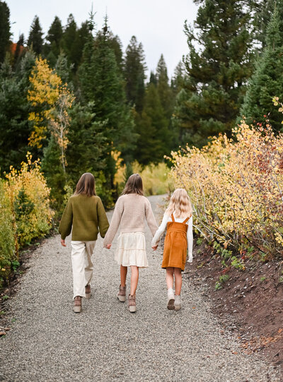 Girls walking away hand in hand in Cottonwood Canyon, Utah.