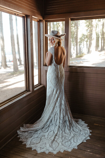 bride in hat on wedding day log cabin