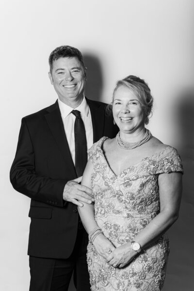 Playful black and white portrait of a couple laughing and holding flowers during a Vogue Portrait photo booth session in Richmond, VA.