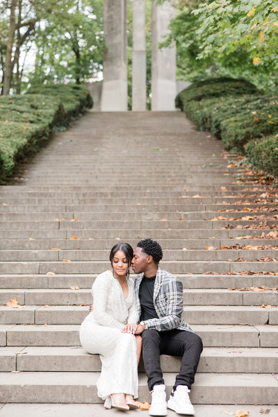 couple sitting on steps at Holcomb Gardens photographed by Kaitlin Mendoza Photography, an Indianapolis engagement photographer