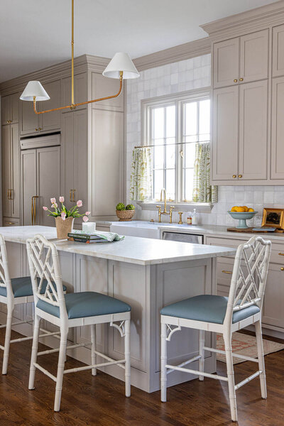 A blue kitchen with floral wallpaper opening into a purple dining room with orange curtains and a marble countertop.