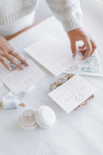 Hands arranging a wedding invitation