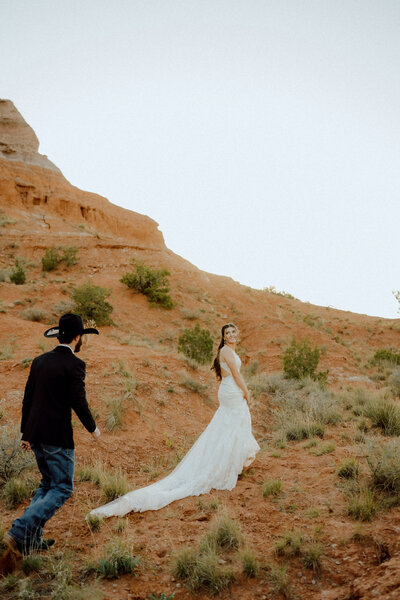 bride and groom running together at their oklahoma elopement