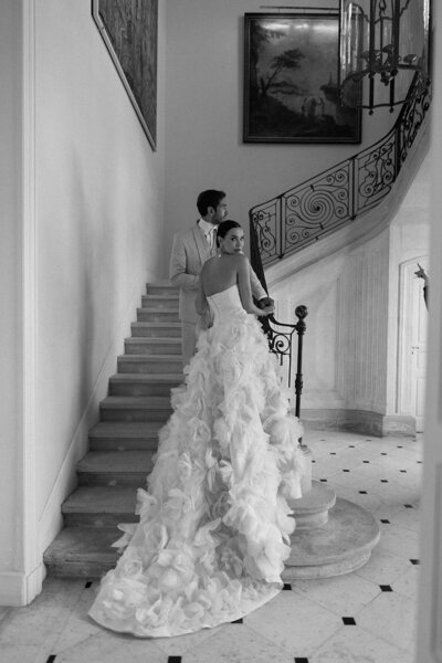 Bride and groom posing on the grand winding staircase inside Château de Tourreau during their editorial wedding portraits.