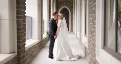 couple kissing in cathedral hallway