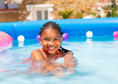 The little girl is all smiles by the pool, radiating joy and happiness