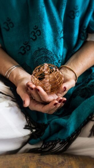 A woman is sitting while holding a round object