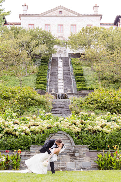 Milwaukee wedding bride and groom dip kiss in front of Villa Terrace wedding venue. 