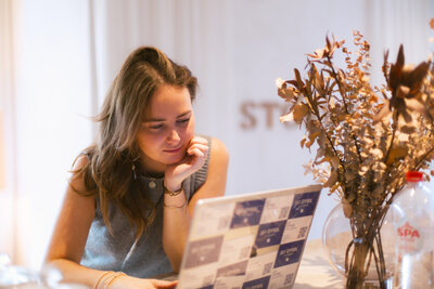 Bo Eppink guiding Eloise van Oranje on how to review photo previews on a digital camera, showcasing the value of mastering camera settings in a relaxed, creative environment.