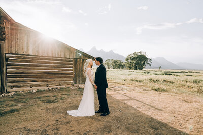 bride and groom holding hands outside of ranch building