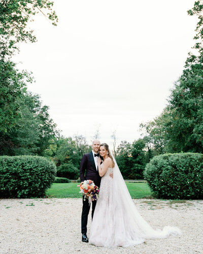 Bride and groom looking towards the camera next to each other at their Glenstone Gardens wedding.