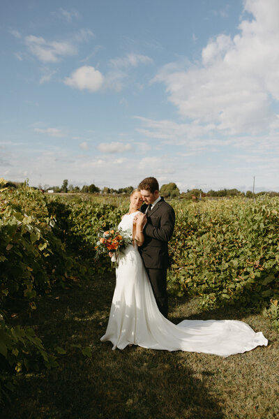 bride and groom posing for wedding photos at prince edward island