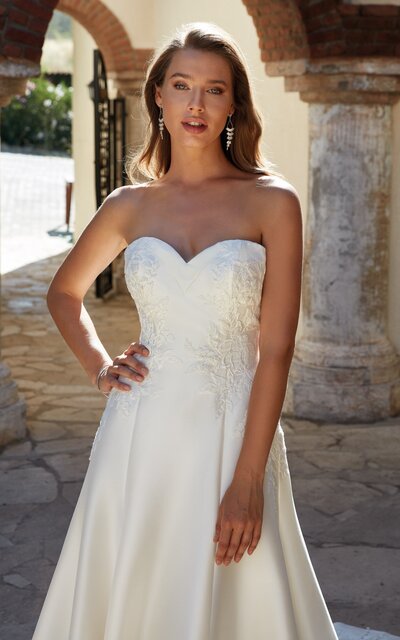 Looking to show off your shoulders and collarbones? This sophisticated crepe sheath bridal dress features an off-the-shoulder neckline and lacy straps to help you do just that.