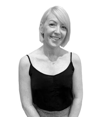 Female Art Director with a sleek blonde bob and a black camisole, showcasing leadership as a Salon Manager in Sydney.
