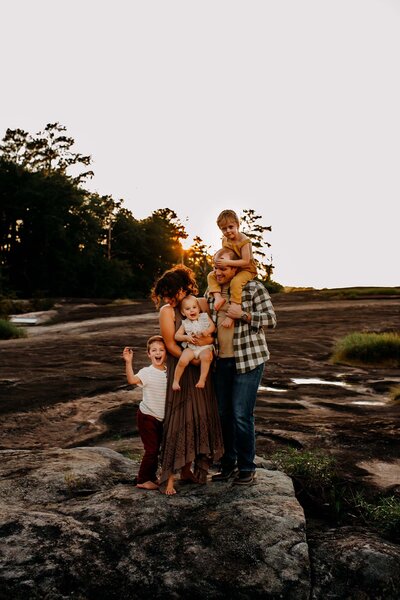 A family of 5 standing on a mountain top in Atlanta, Ga during sunset