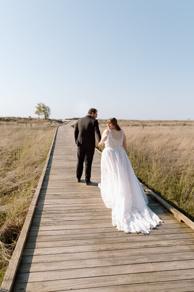 Bride and groom walking down a path at Headlands Beach State Park.