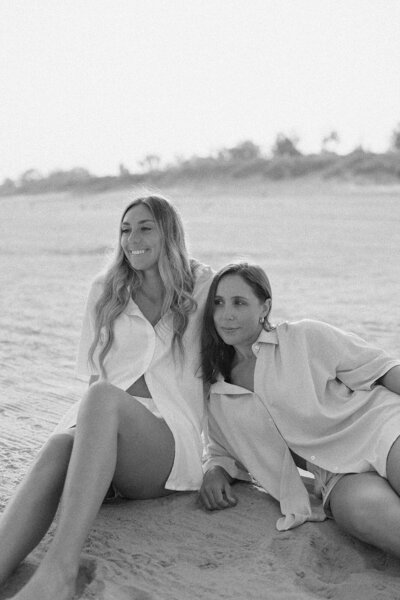 Two women posing together on the beach in St. Joseph, Michigan during their branding photo session.