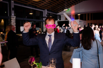guests dancing with neon glasses during reception