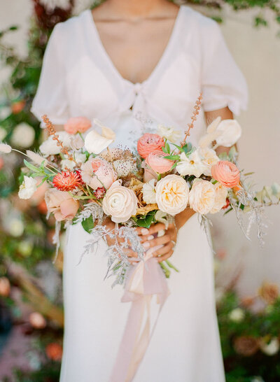 Peach and cream bridal bouquet with a trailing silk ribbon