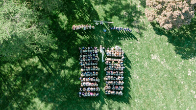 Aerial view of an outdoor wedding ceremony in Virginia, with guests seated in rows as the couple exchanges vows