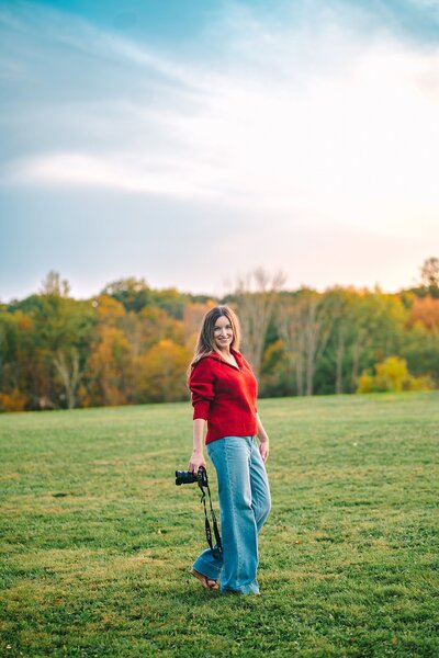 Gina Cooperman of Joy Alexander Photography sits casually on a swing