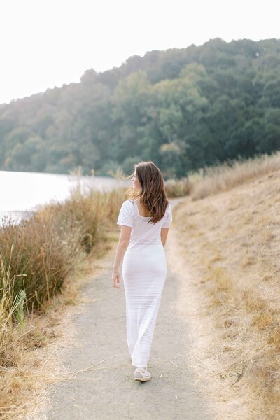 senior girl wearing a white dress and smiling with her mouth closed