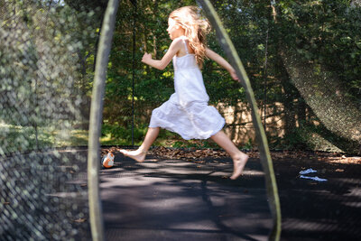 Documentary family photography with child swinging outdoors and parent nearby