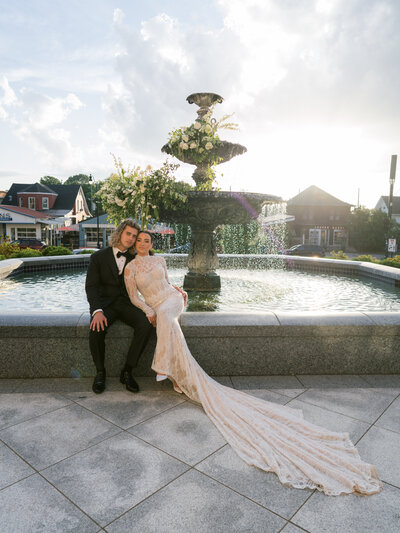 Bride and groom first dance under colored flowers and pastel chandeliers.