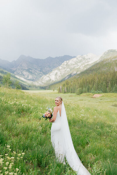 Elegant bridal portrait with wind-blown veil and soft mountain light | Colorado fine art photographer