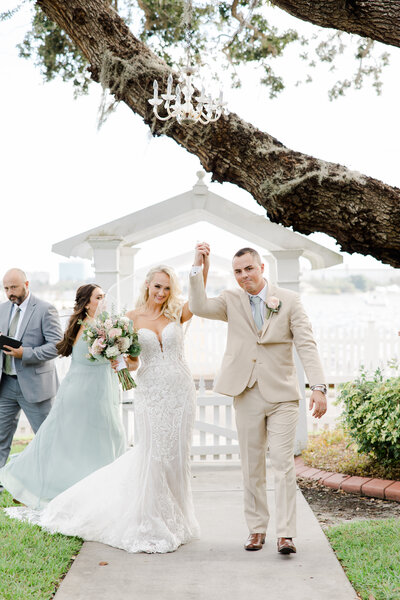 bride and groom holding hands as they exit wedding ceremony