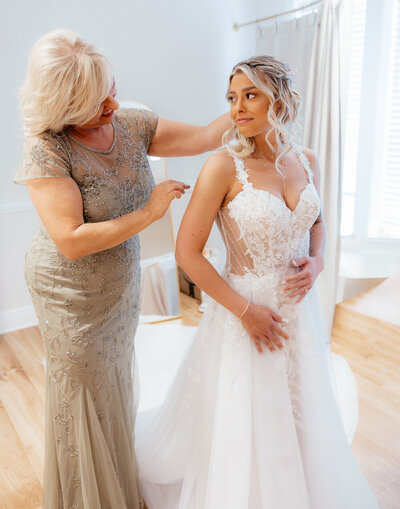The mother of the bride is putting the bride's veil. 