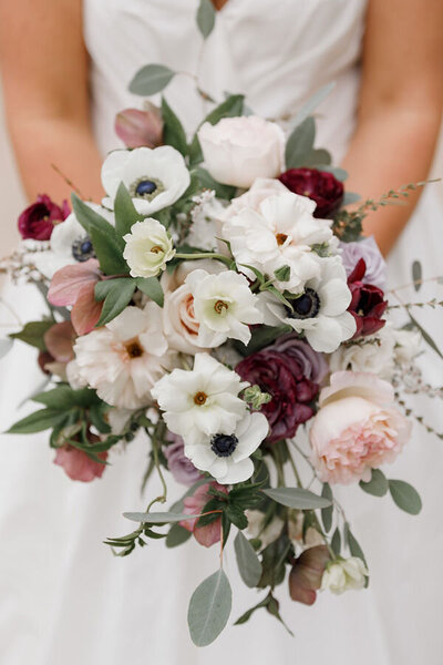 Luxurious bouquet with cascading orchids, roses, and textured greenery, crafted by Leigh Florist for a modern wedding.
