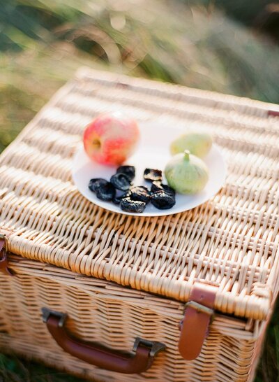 Straw picnic basket with fruits on a plate