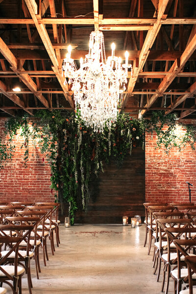Rich brown walnut ceremony backdrop with lush florals