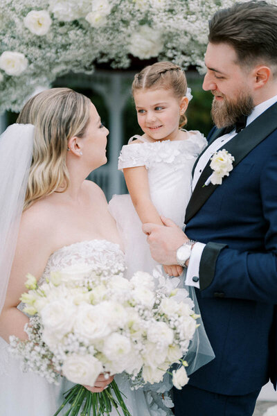 Bride, groom, and flower girl share a joyful moment at their Deer Creek wedding – captured by Toronto wedding photographer