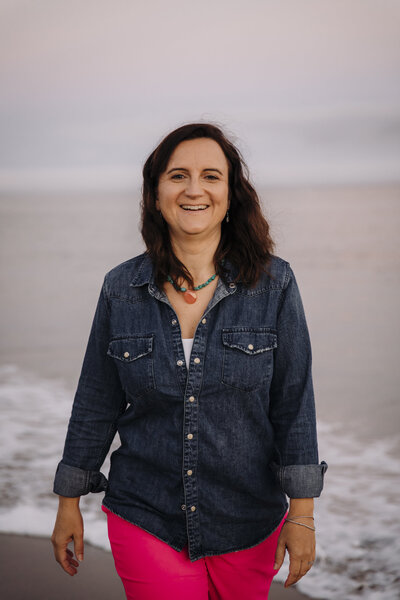 Yvonne, licensed midwife in Oʻahu, smiling during a beachside headshot session