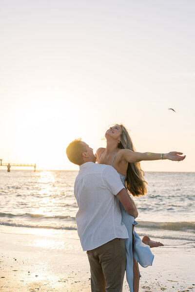 engaged couple holding hands near a tree