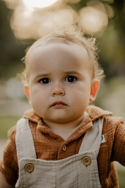 Outdoor family photoshoot in Omaha park during golden hour – capturing candid, heartfelt moments.