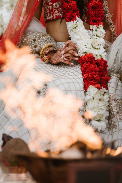 Indian Hindu wedding ceremony at the Hilton Waikoloa Village, featuring a traditional fire pit as part of the sacred rituals, capturing a beautiful moment from a luxury destination wedding in Hawaii.