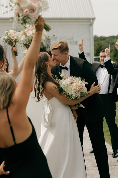 Fun bridal party portraits of bride and groom kissing documented by Alabama timeless wedding photographer