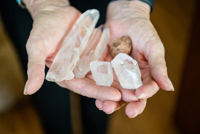 Audrie Meyer's hands holding healing crystals used for spiritual coaching and transformation beyond trauma.