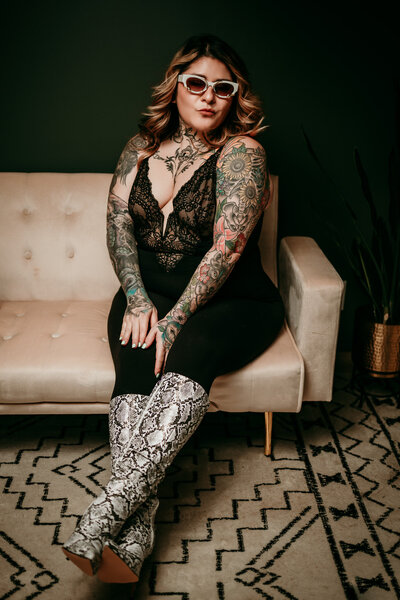 woman in studio sitting on white bench wearing black pants and black top