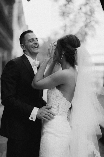 Bride and groom laugh with each other on their wedding day