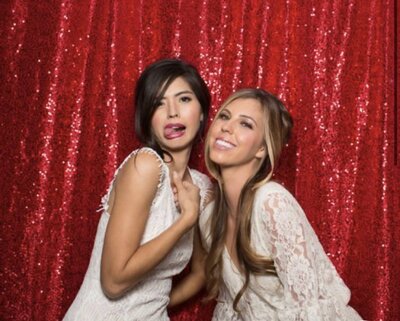 Girls being silly posing in front of red sequin photo booth backdrop