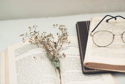 open books on a desk with a pair of glasses