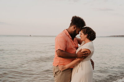 Couple d'un homme et une femme front contre front sur la plage face à la mer