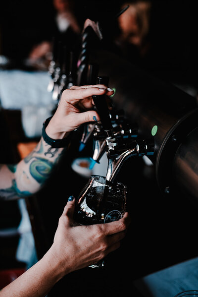 Professional brand photo of beer being poured from a tap at a local brewery, showcasing craftsmanship and ambiance